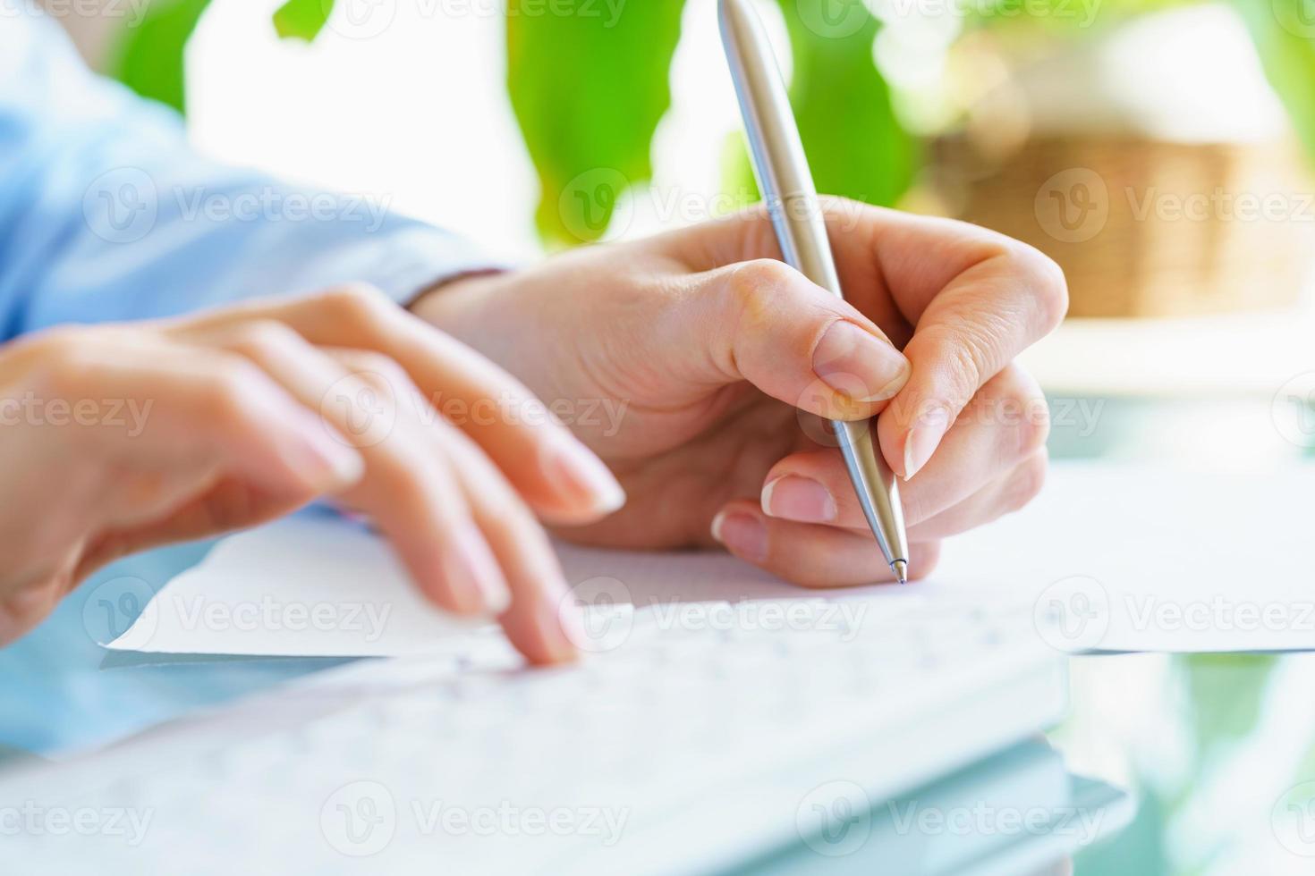 Frau Büro Arbeiter mit Stift im Hand Tippen auf das Tastatur foto