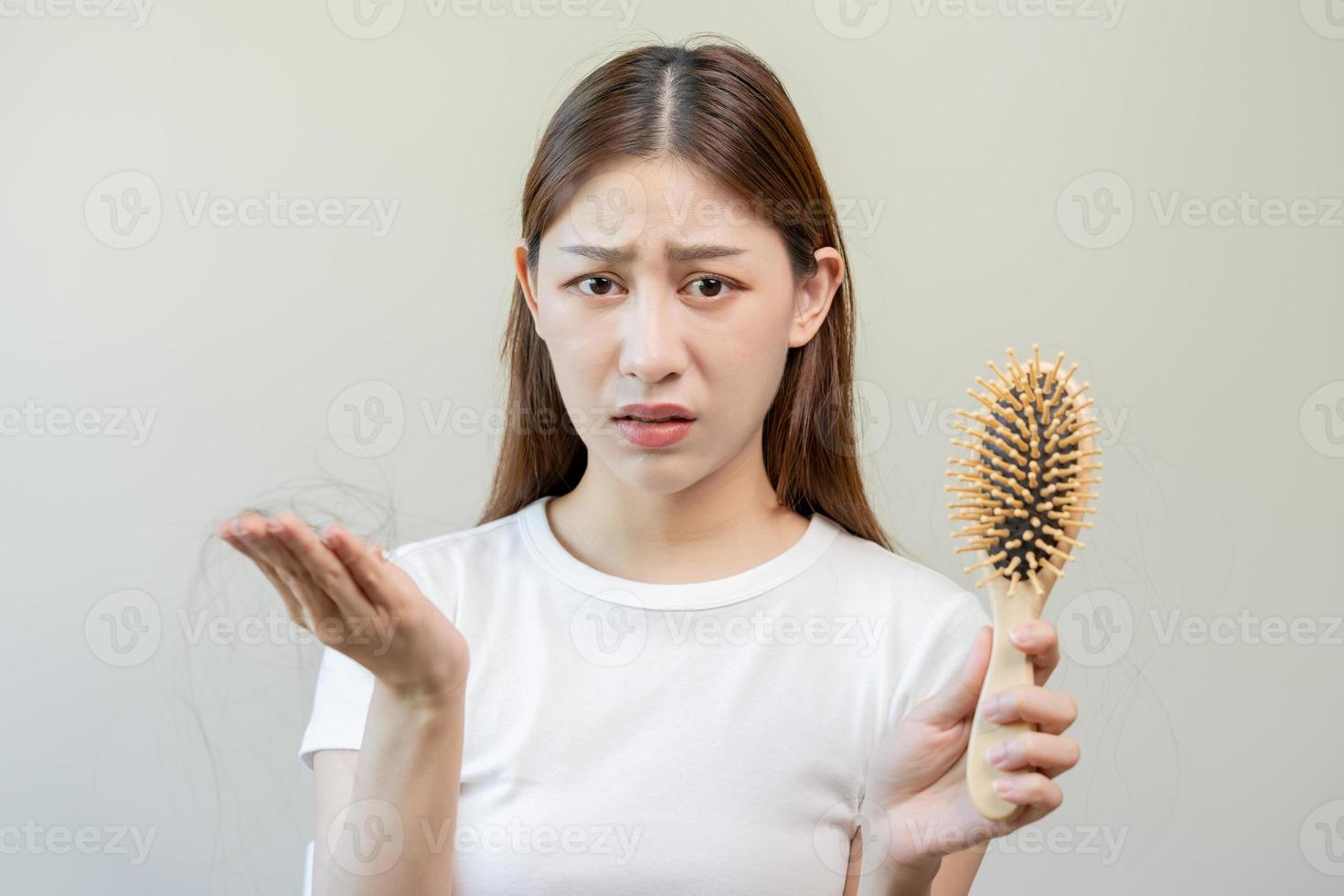 ernst, besorgt asiatisch jung Frau, Mädchen halten Kamm, Show ihr Haarbürste mit lange Verlust Haar Problem nach Bürsten, Haar fallen aus Problem. Gesundheit Pflege, Schönheit mit Kopieren Raum auf Weiß Hintergrund. foto