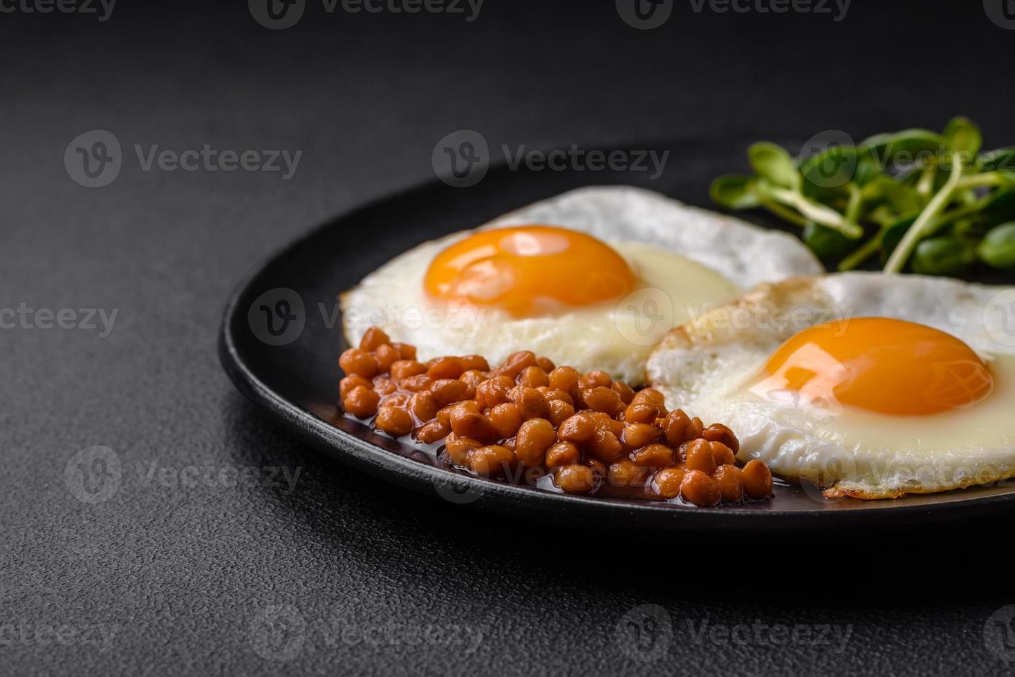 köstlich herzhaft Frühstück bestehend aus von zwei gebraten Eier, Dosen- Linsen und Microgreens foto