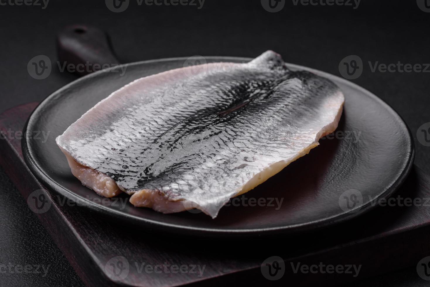köstlich gesalzen Hering Filet im Öl auf ein schwarz Keramik Teller foto