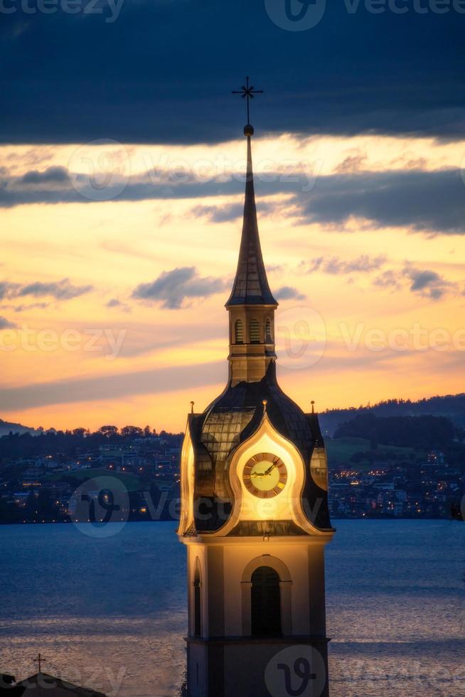 ein beleuchtet Kirche Turm beim Sonnenuntergang foto