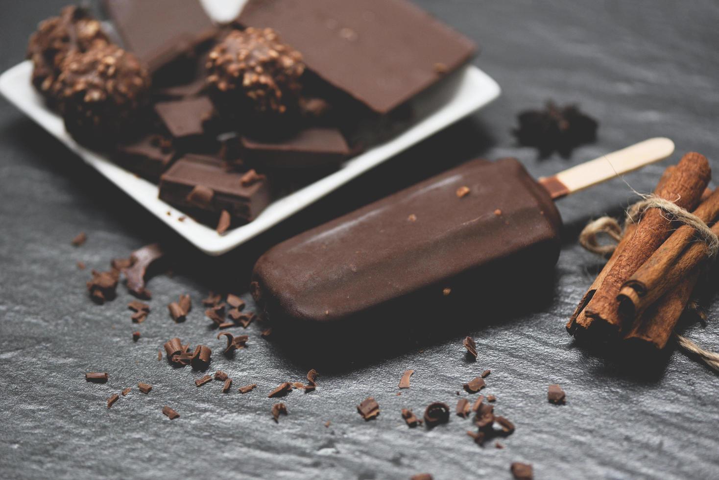 Eis Sahne Stock mit würzen Schokolade Bar und Ball auf dunkel Hintergrund - - Eis Sahne bedeckt Schokolade gefroren Eis am Stiel Süss Dessert oder Snack foto