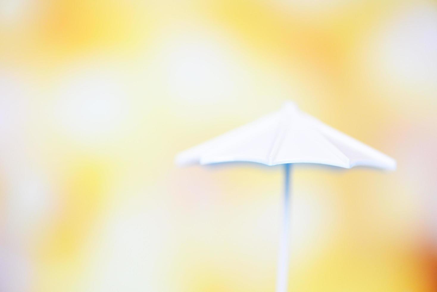schließen oben Weiß Regenschirm auf Bokeh und Gelb verwischen Hintergrund foto