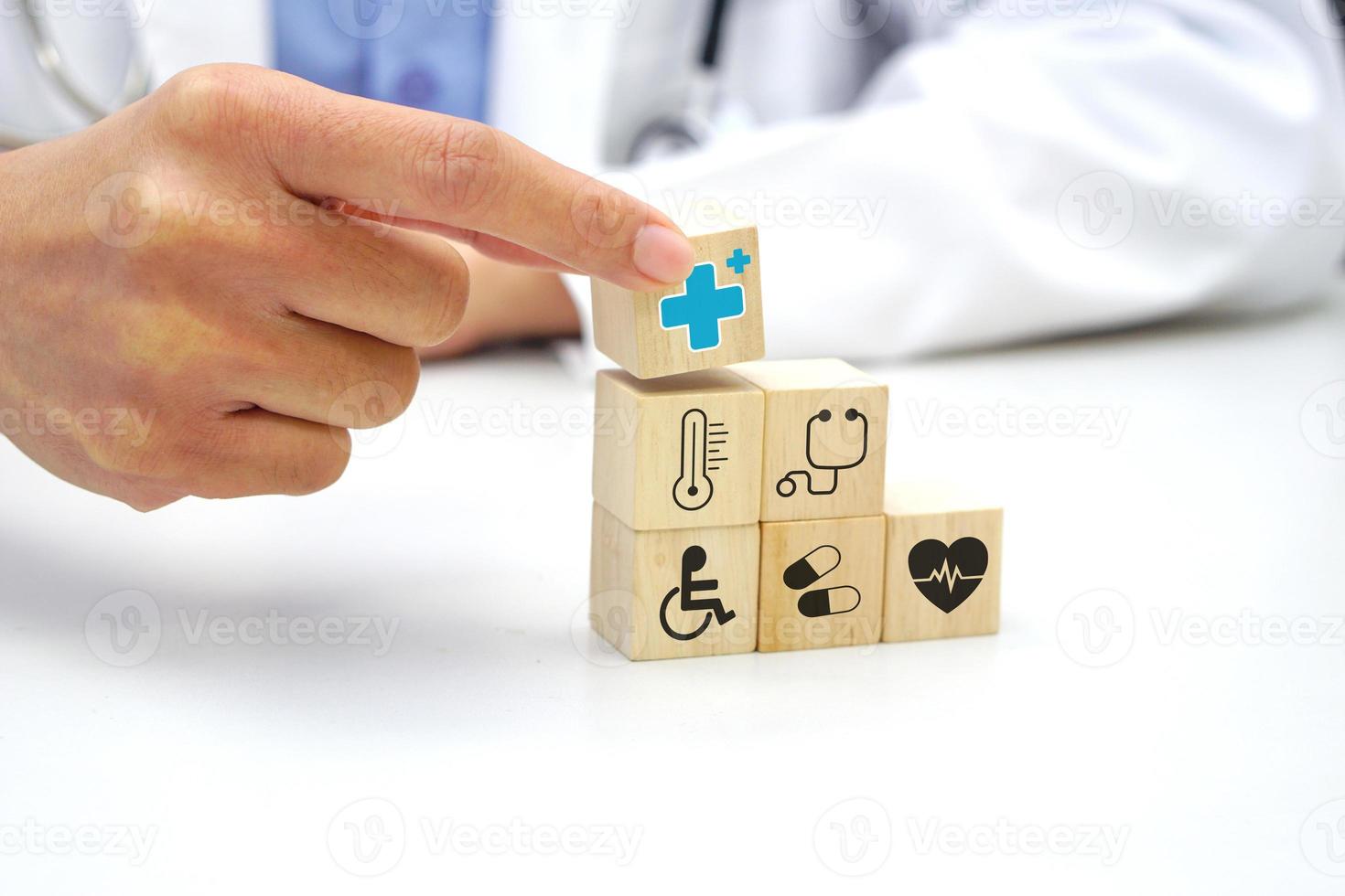 Hand, die einen Holzblockwürfel mit medizinischem Symbolsymbol im Gesundheitswesen hält. medizinisches und gesundheitskonzept. foto