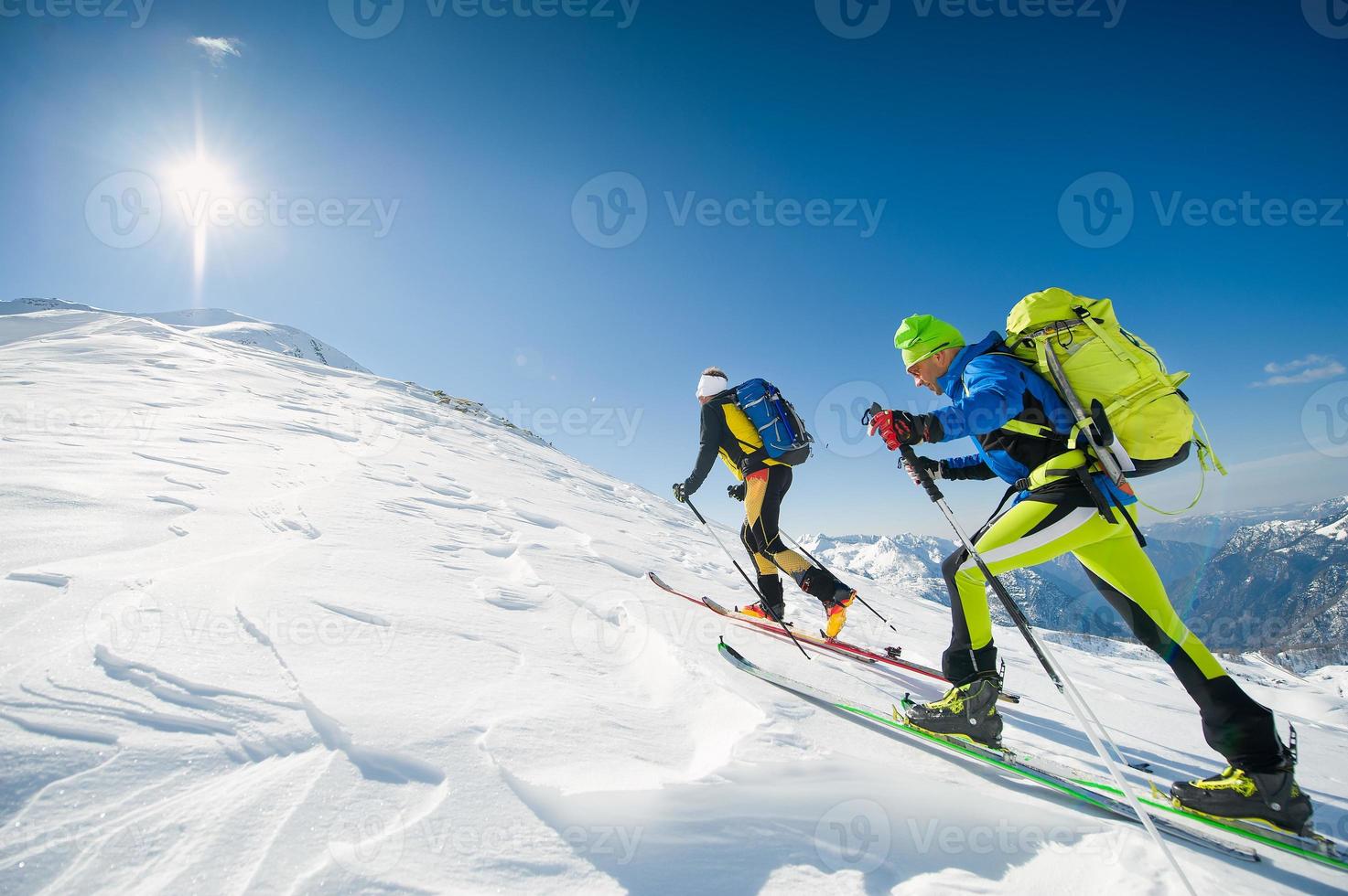 Langlauf-Team fahren in Richtung des Berggipfels foto