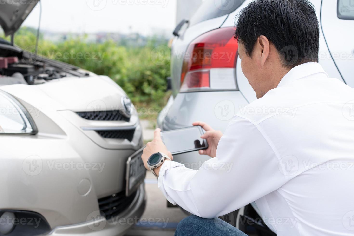 asiatisch Männer Treiber prüfen zum Beschädigung nach ein Auto Unfall Vor nehmen Bilder und Senden Versicherung. online Auto Unfall Versicherung Anspruch nach einreichen Fotos und Beweise zu ein Versicherung Unternehmen.