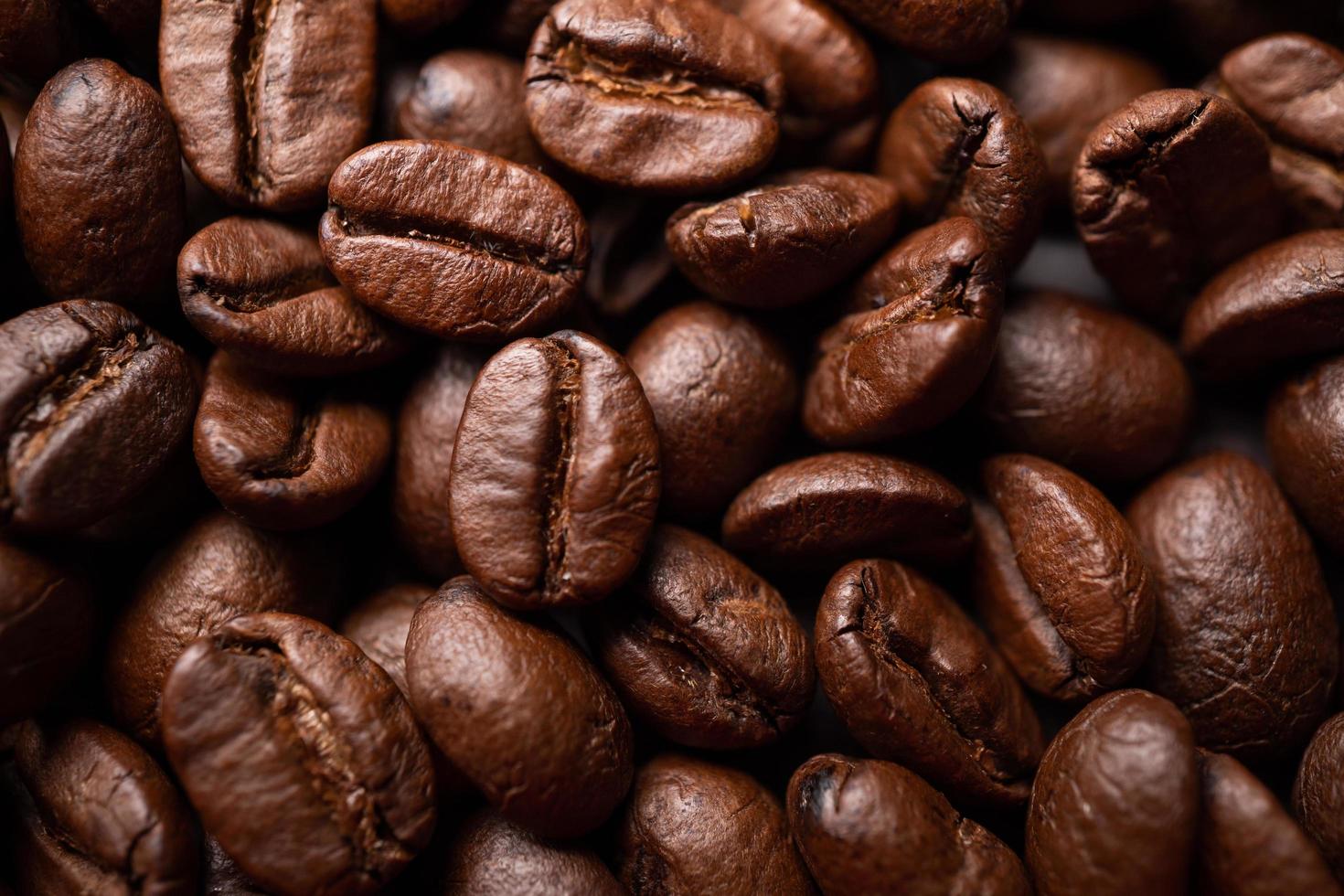 schließen oben von Gruppe schwarz Kaffee Bohnen. stark schwarz Espresso, Gründe von Kaffee Hintergrund, Textur foto