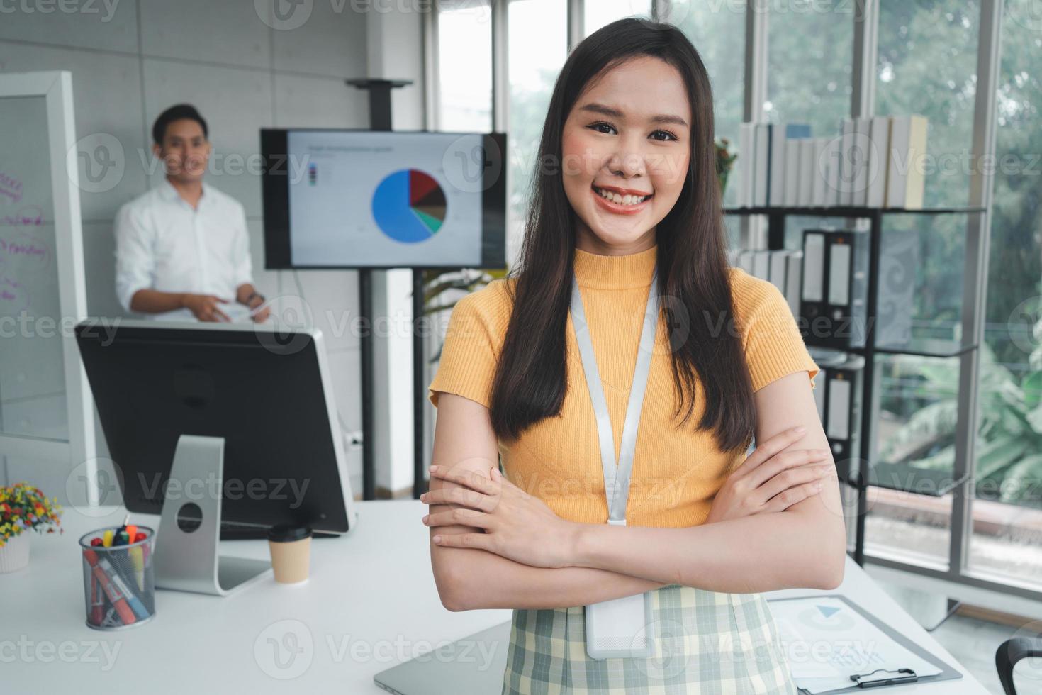 junge asiatische glückliche geschäftsfrau oder praktikantin im modernen bürohintergrund diskutieren kollegen mit einer neuen startprojektidee. Befähigter digitaler Unternehmer arbeitet an Startup-Projekt foto