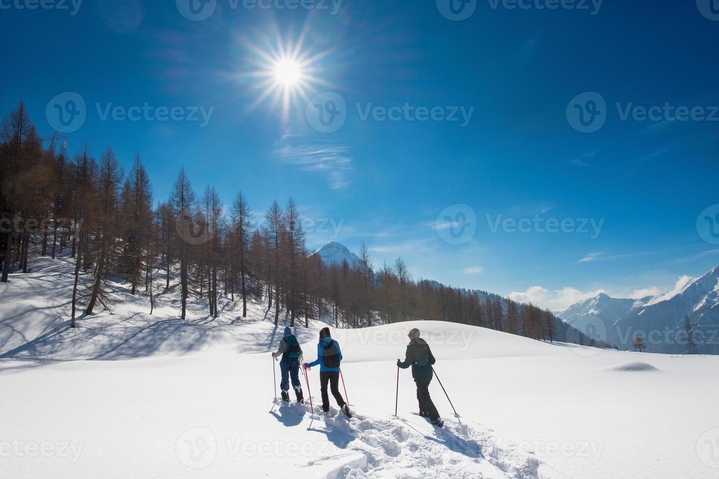 drei Mädchen auf einer Schneeschuhwanderung foto