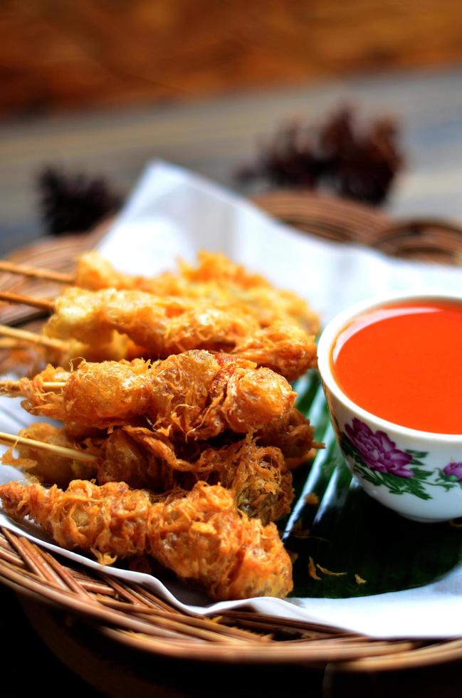 selektiv Fokus cilor Tusuk oder aci telur gulung ist ein typisch indonesisch Snack. serviert auf hölzern Tabelle foto