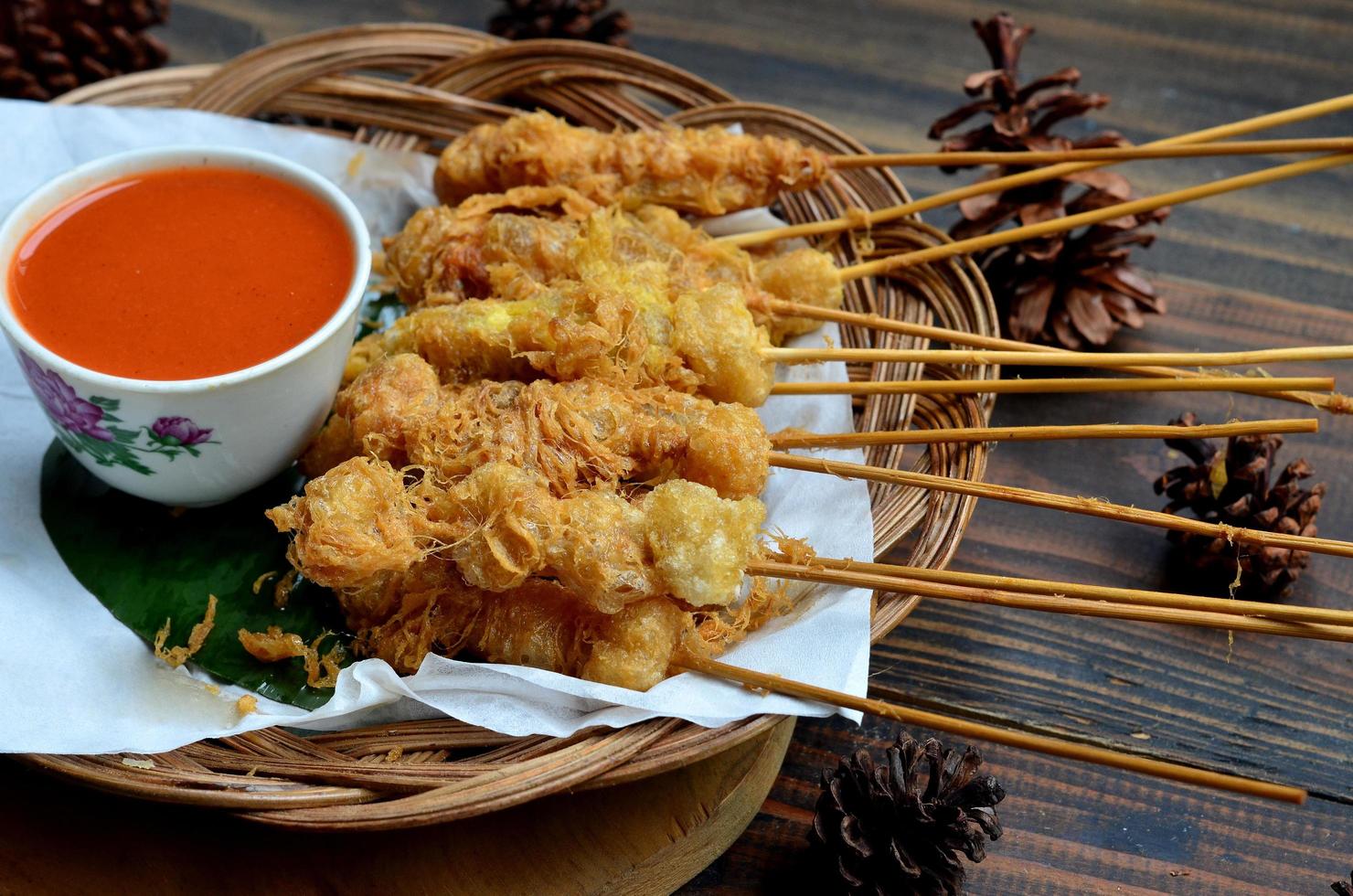 selektiv Fokus cilor Tusuk oder aci telur gulung ist ein typisch indonesisch Snack. serviert auf hölzern Tabelle foto