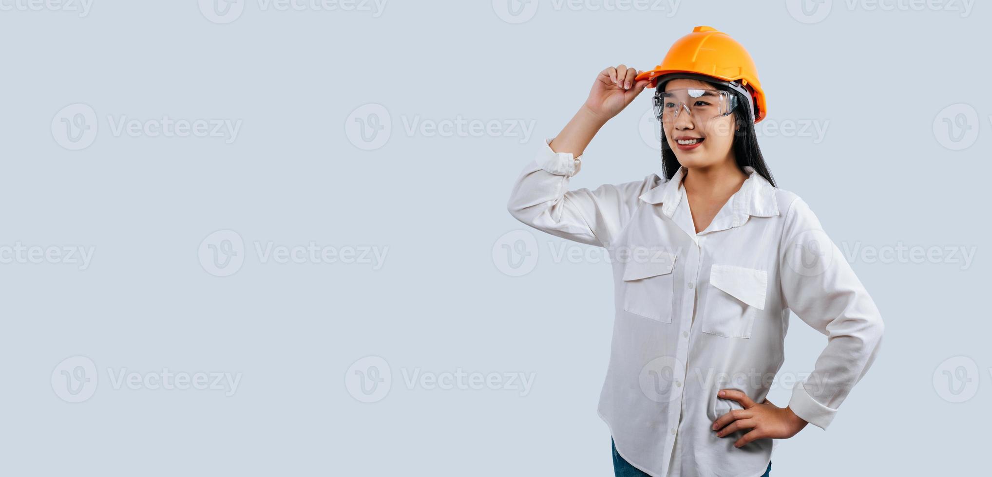 jung weiblich Ingenieur tragen Gelb Helm Stand mit charmant Lächeln Haltung foto