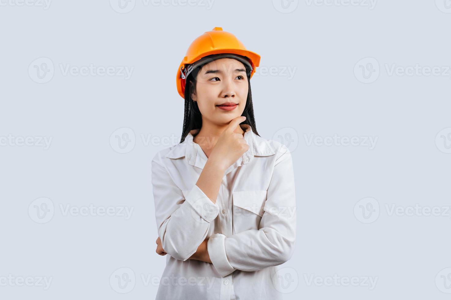 jung weiblich Ingenieur im Helm Stand mit nachdenklich Haltung foto