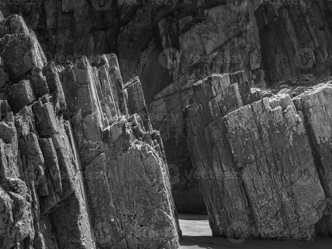 Felsen mit geraden Kanten bei Ebbe eines Strandes an der asturischen Küste foto