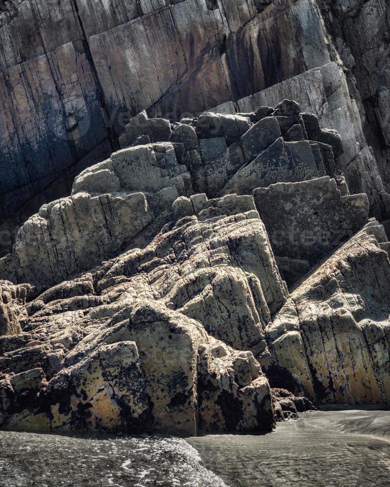 Felsen mit geraden Kanten bei Ebbe eines Strandes an der asturischen Küste foto