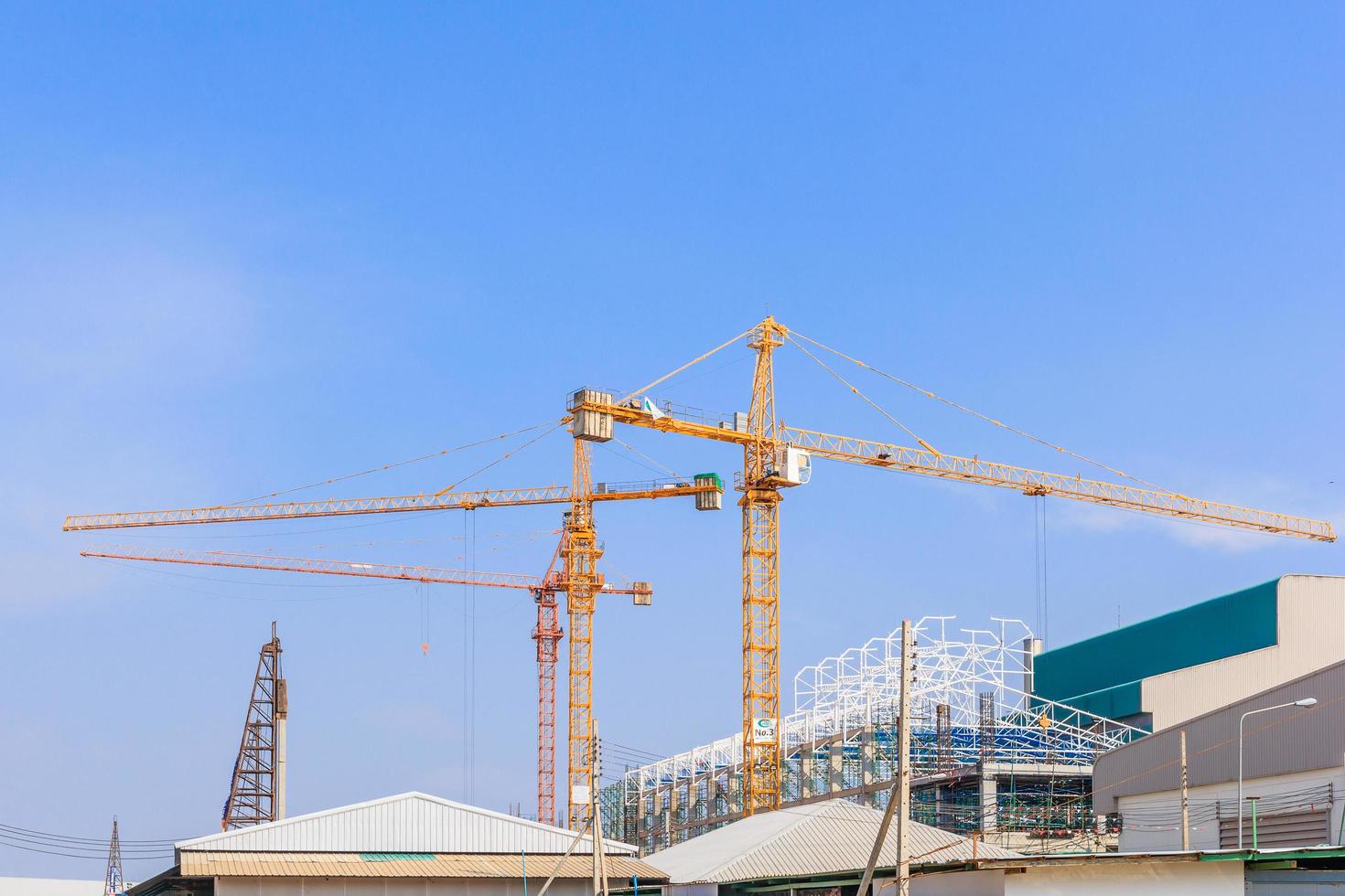 Industriebaukräne und Gebäude in einem schönen blauen Himmelhintergrund foto