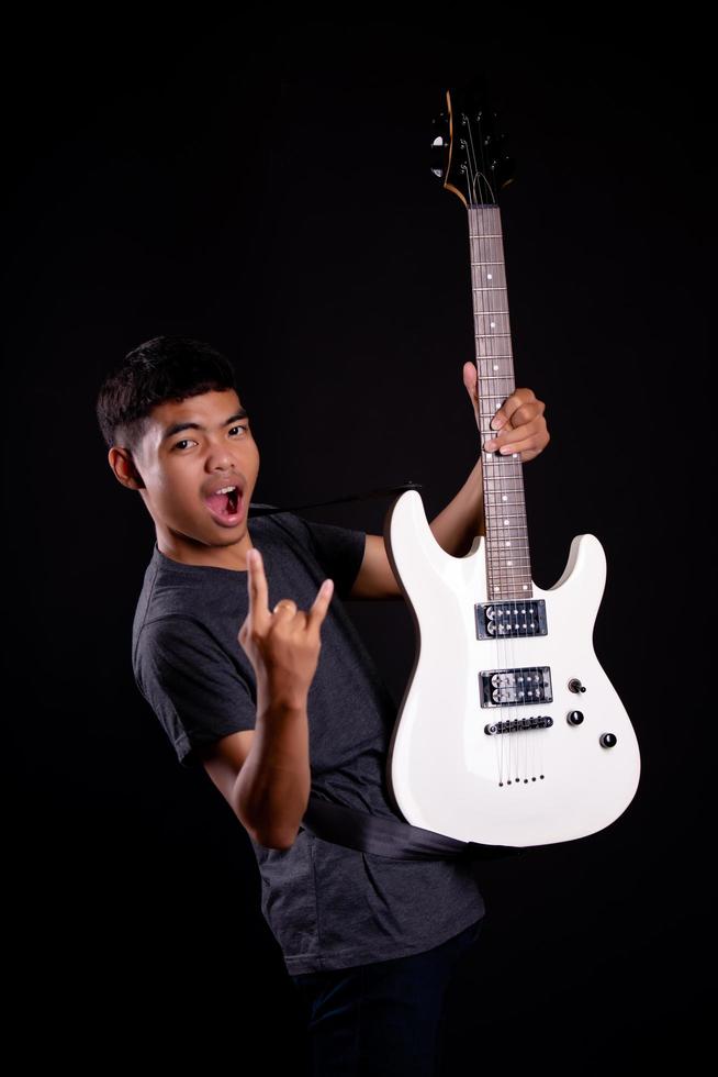 junger Mann mit E-Gitarre im Studio foto