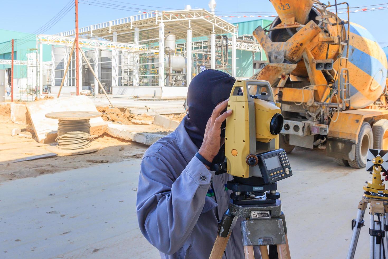 Vermessungsarbeiter, der auf der Baustelle mit Theodolitgeräten misst. foto