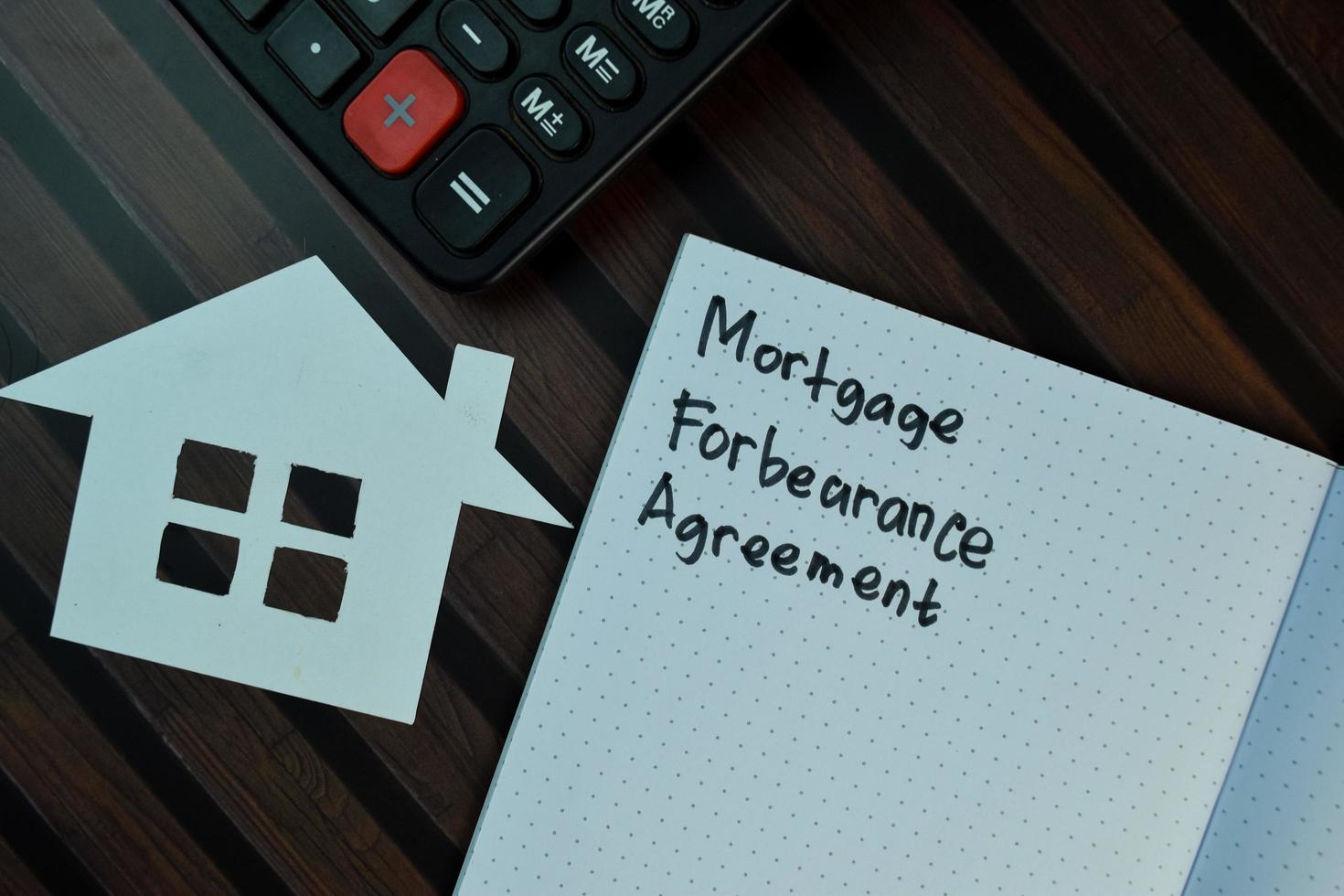 Hypotheken-Nachsichtsvereinbarung geschrieben auf Haftnotiz isoliert auf Holztisch foto