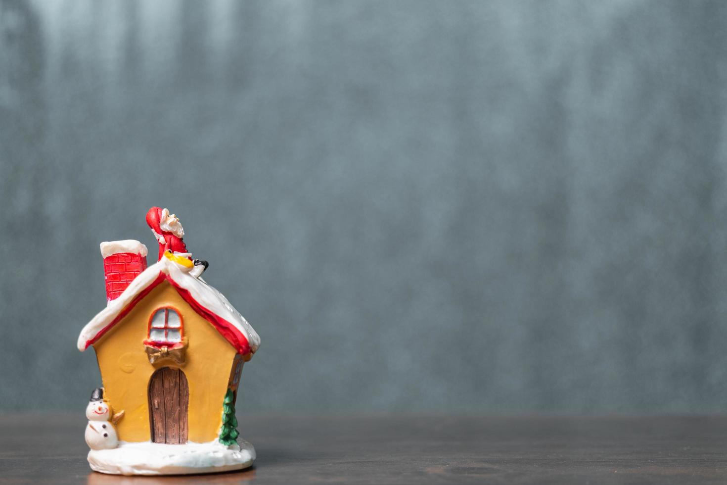 Miniatur-Weihnachtsmann, der auf einem Dach sitzt, Weihnachtslegende und frohe Feiertagskonzept foto