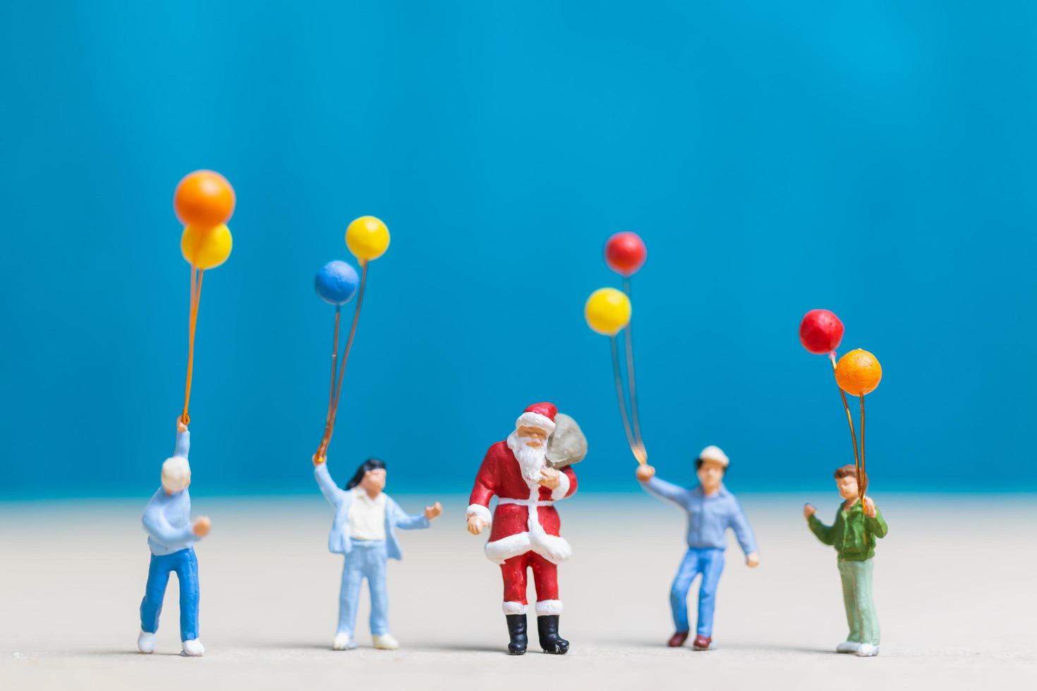 Miniatur-Weihnachtsmann und Kinder, die Luftballons, frohe Weihnachten und ein frohes neues Jahr-Konzept halten foto
