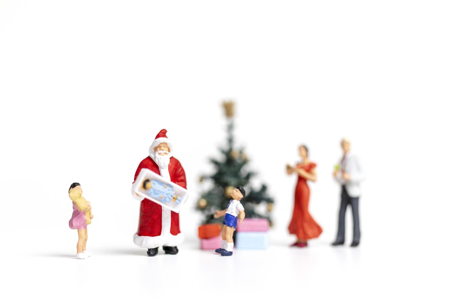 Miniatur-Weihnachtsmann, der Geschenke für eine glückliche Familie, Weihnachten und ein frohes neues Jahr-Konzept hält foto