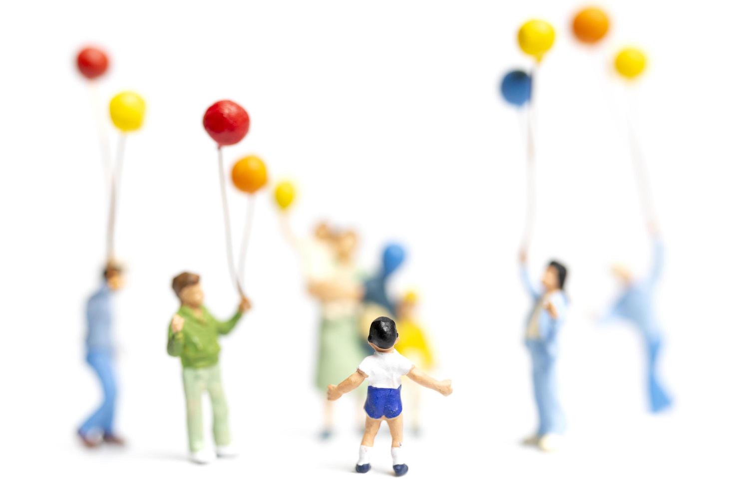 Miniaturkinder, die Luftballons auf einem weißen Hintergrund halten foto