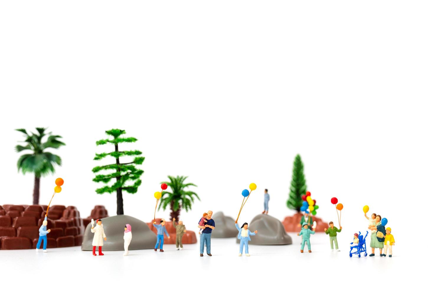 Miniaturfamilie, die Luftballons im Park hält, Weltkindertagskonzept foto