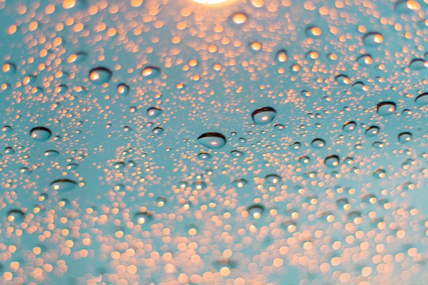 abstrakter Hintergrund von unscharfen Wassertropfen und Licht auf Glas foto