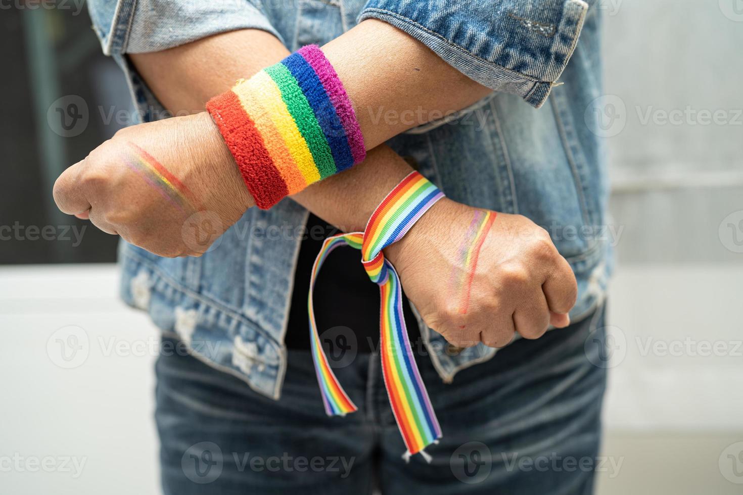 asiatisch Dame tragen Regenbogen Flagge Armbänder isolieren auf Weiß Hintergrund, Symbol von lgbt Stolz Monat feiern jährlich im Juni Sozial von Fröhlich, lesbisch, bisexuell, Transgender, Mensch Rechte. foto