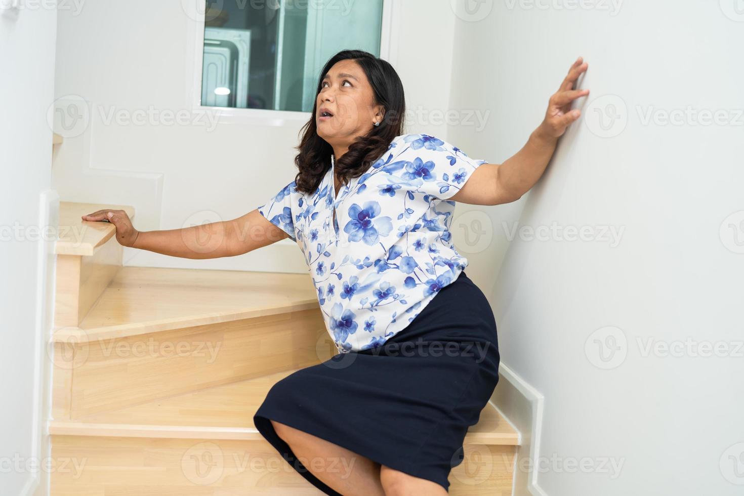 asiatisch Dame fallen Nieder das Treppe und Schmerzen beim Hüfte und Taille weil rutschig Oberflächen. foto