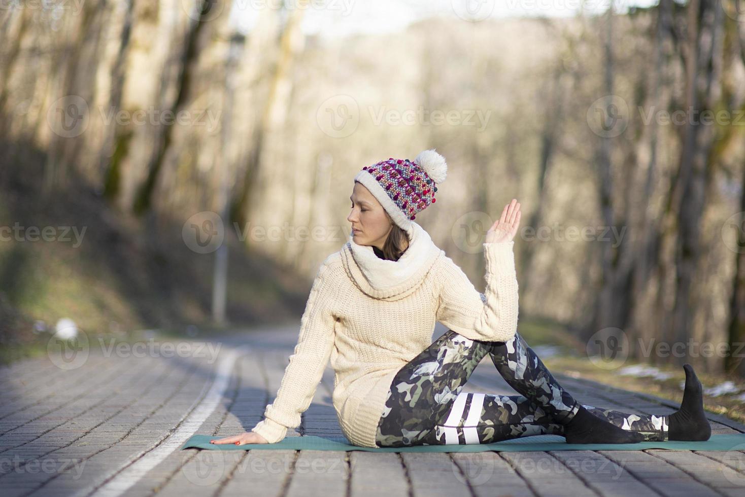 Eine junge sportliche Frau führt Yoga und Meditationsübungen im Freien durch foto