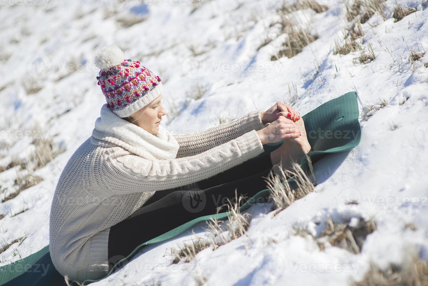 Eine junge sportliche Frau führt Yoga und Meditationsübungen im Freien durch foto