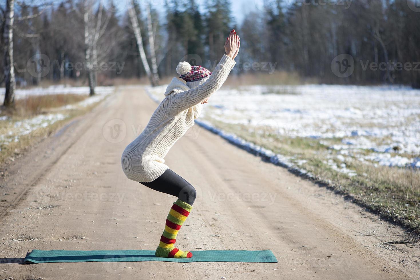 Eine junge sportliche Frau führt Yoga und Meditationsübungen im Freien durch foto