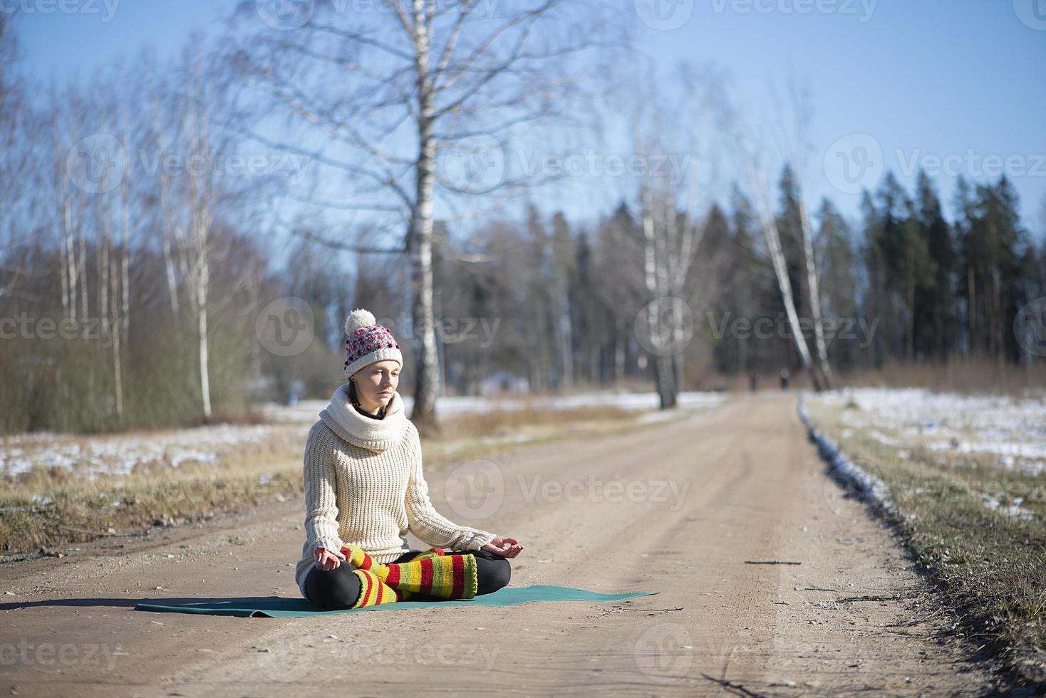 Eine junge sportliche Frau führt Yoga und Meditationsübungen im Freien durch foto