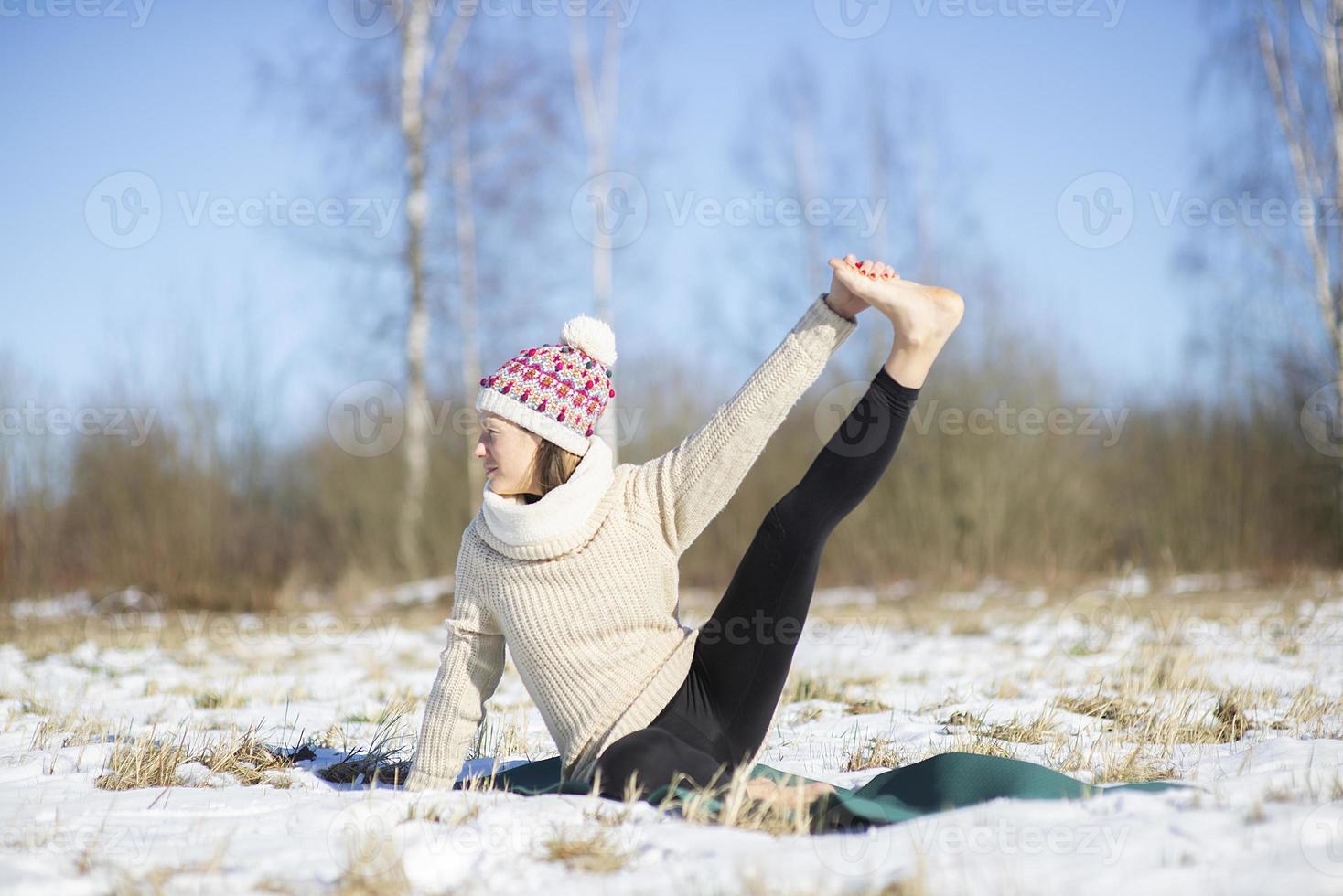 Eine junge sportliche Frau führt Yoga und Meditationsübungen im Freien durch foto