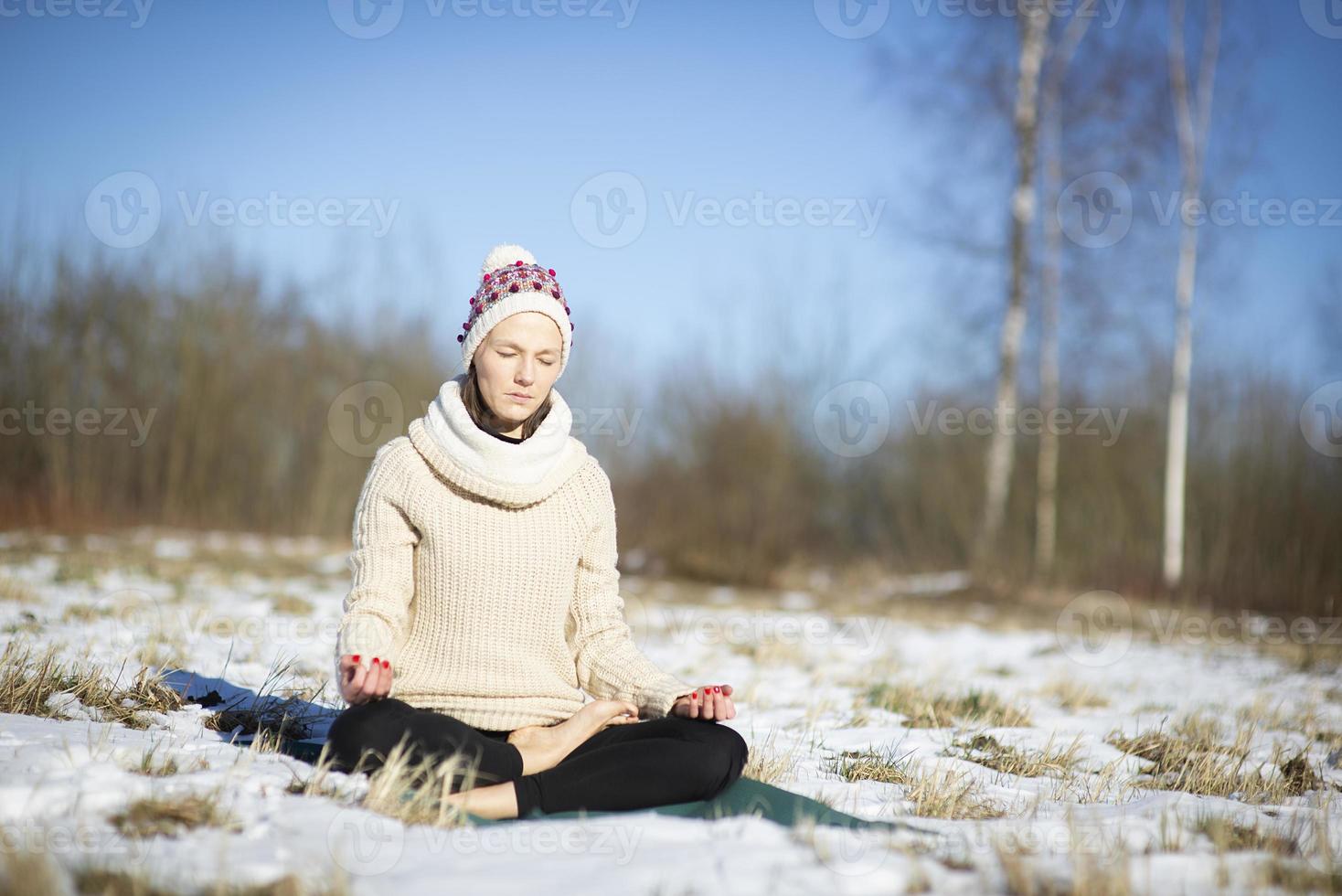 Eine junge sportliche Frau führt Yoga und Meditationsübungen im Freien durch foto