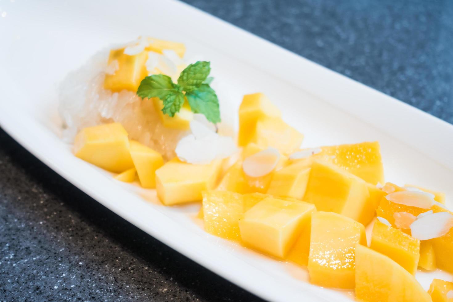 Mango mit Klebreis auf weißem Teller foto