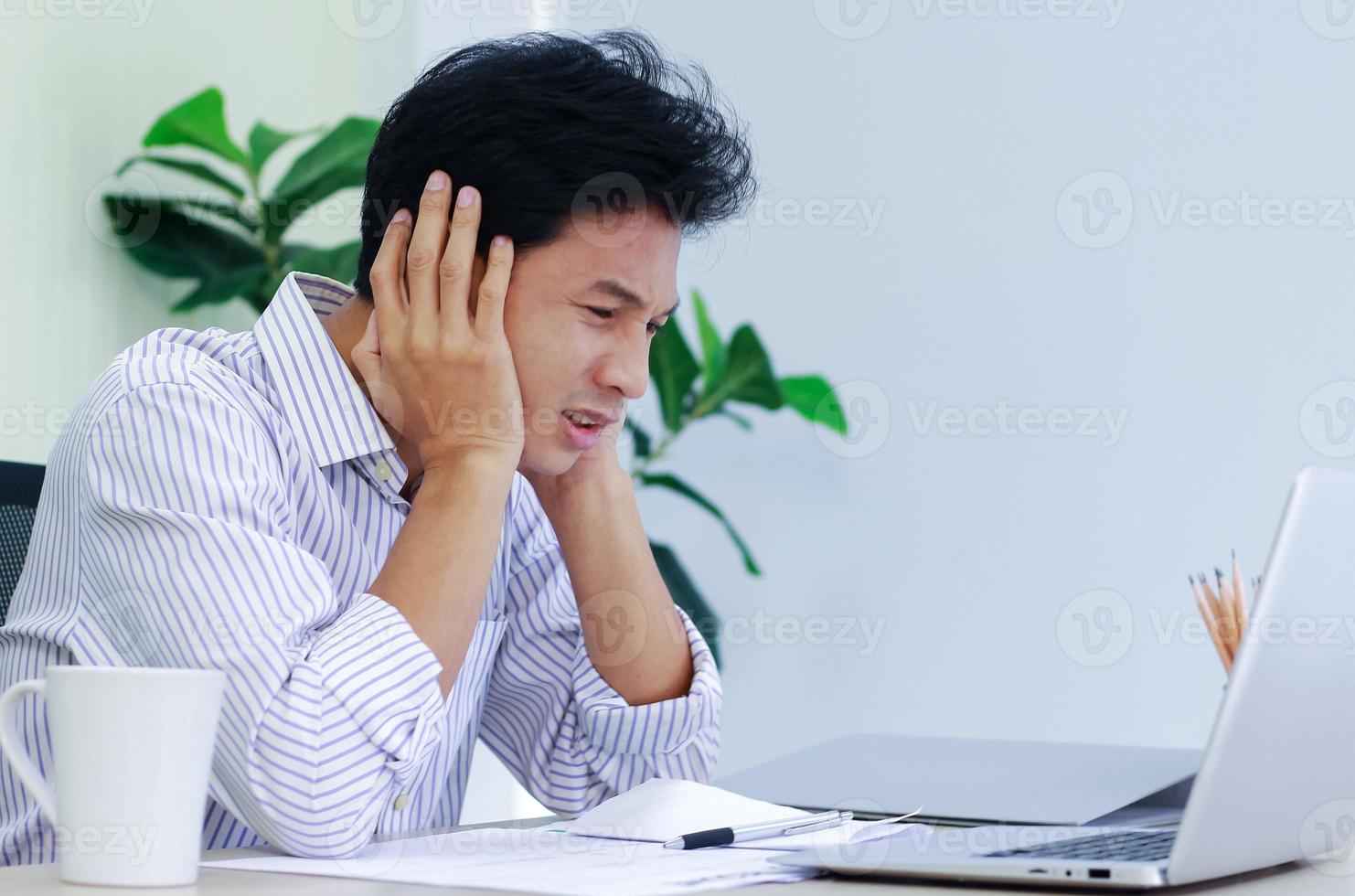 junger Geschäftsmann am Schreibtisch gestresst foto