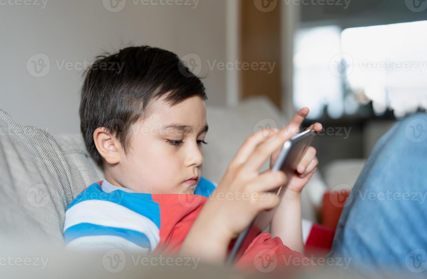 Bildung Konzept, Schule Kind mit Tablette bereiten Geschichte von Internet, Junge studieren online Lernen beim Zuhause, Kind halten Digital Pad mit W-lan spielen Spiel oder chatten mit freunde.zurück zu Schule foto