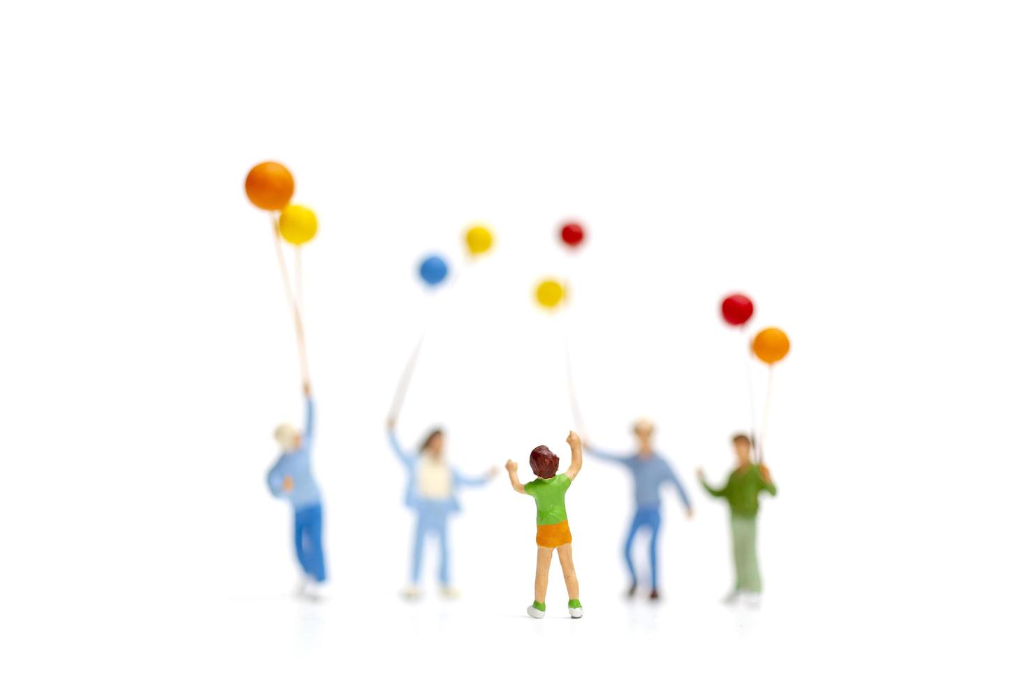 Miniaturkinder, die Ballons lokalisiert auf einem weißen Hintergrund halten, glückliches Familientagkonzept foto
