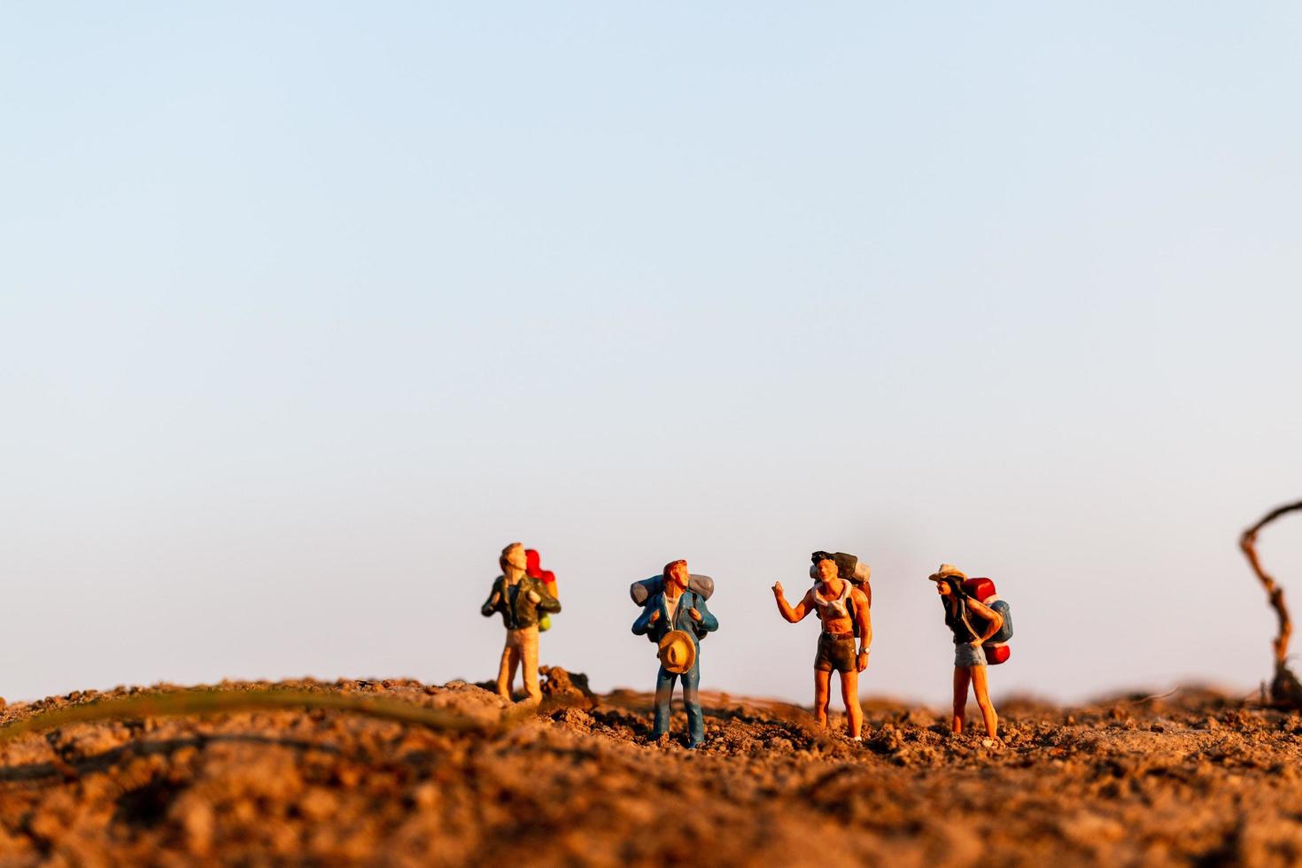 Miniaturreisende mit Rucksäcken Bergsteigen, Wandern und Rucksackwandern im Freien Konzept foto