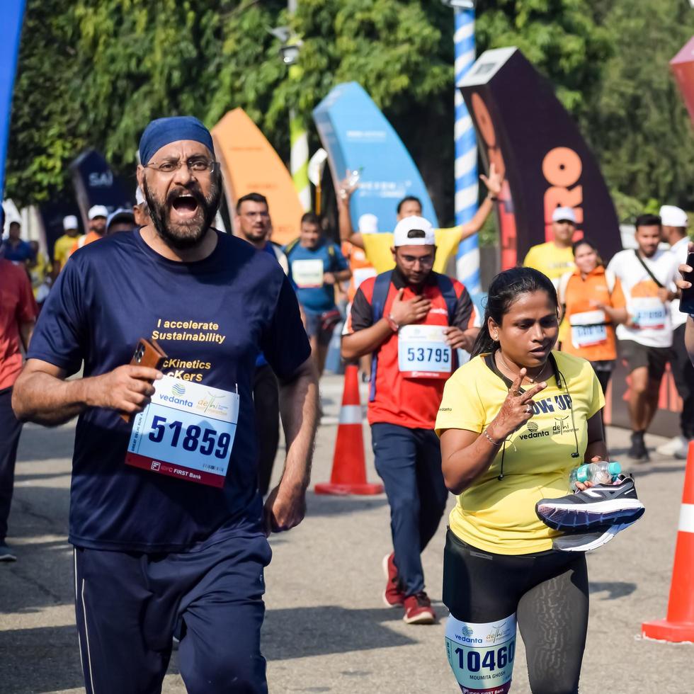 neu delhi, indien - 16. oktober 2022 - vedanta delhi halbmarathonrennen nach covid, bei dem die marathonteilnehmer kurz vor dem überqueren der ziellinie stehen, delhi halbmarathon 2022 foto