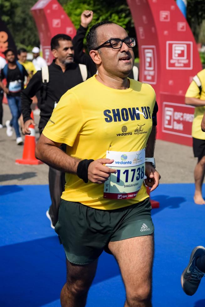 neu delhi, indien - 16. oktober 2022 - vedanta delhi halbmarathonrennen nach covid, bei dem die marathonteilnehmer kurz vor dem überqueren der ziellinie stehen, delhi halbmarathon 2022 foto