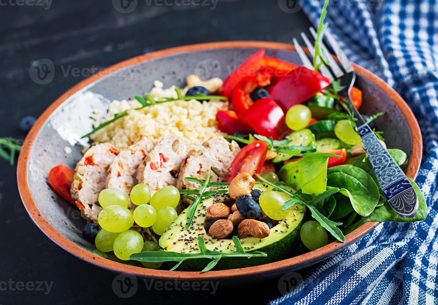 Buddha Schüssel Gericht mit Hackbraten, Bulgur, Avocado, Süss Pfeffer, Tomate, Gurke, Beeren und Nüsse. Entgiftung und gesund Superfoods Schüssel Konzept. foto