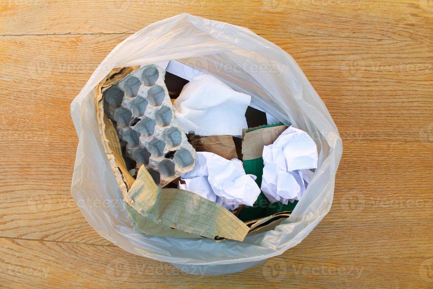 Müll Tasche mit Papier Müll auf hölzern Hintergrund. oben Sicht. foto