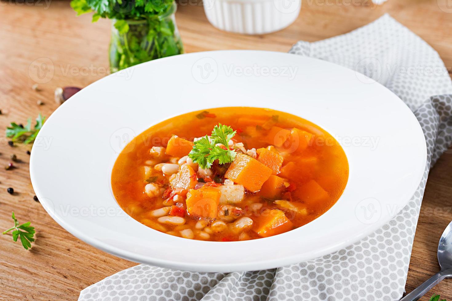 Tomate Hähnchen Suppe mit Kürbis und Weiß Bohnen im Weiß Schüssel. foto