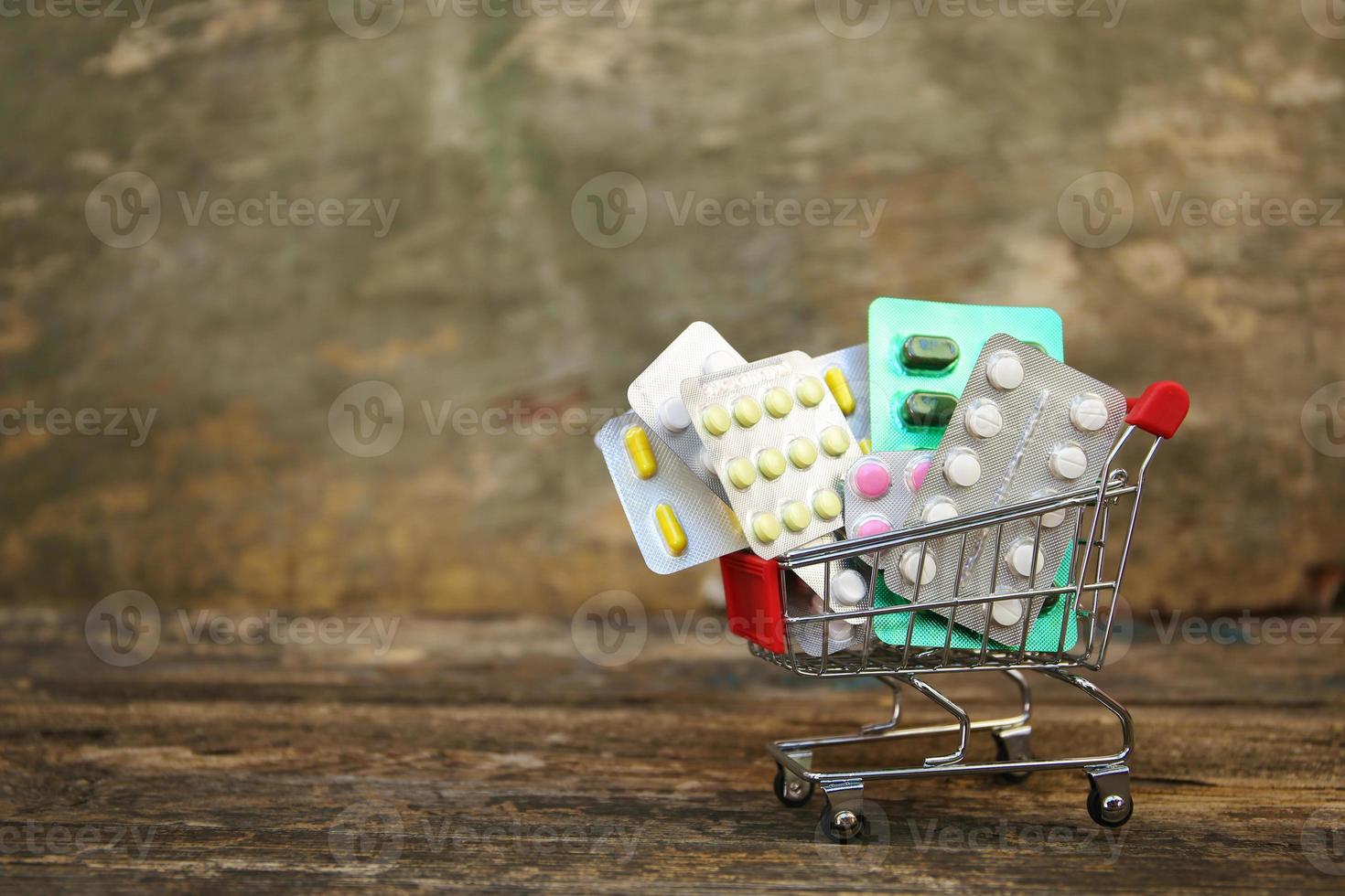 Einkaufen Wagen mit Tabletten auf alt Holz Hintergrund. foto
