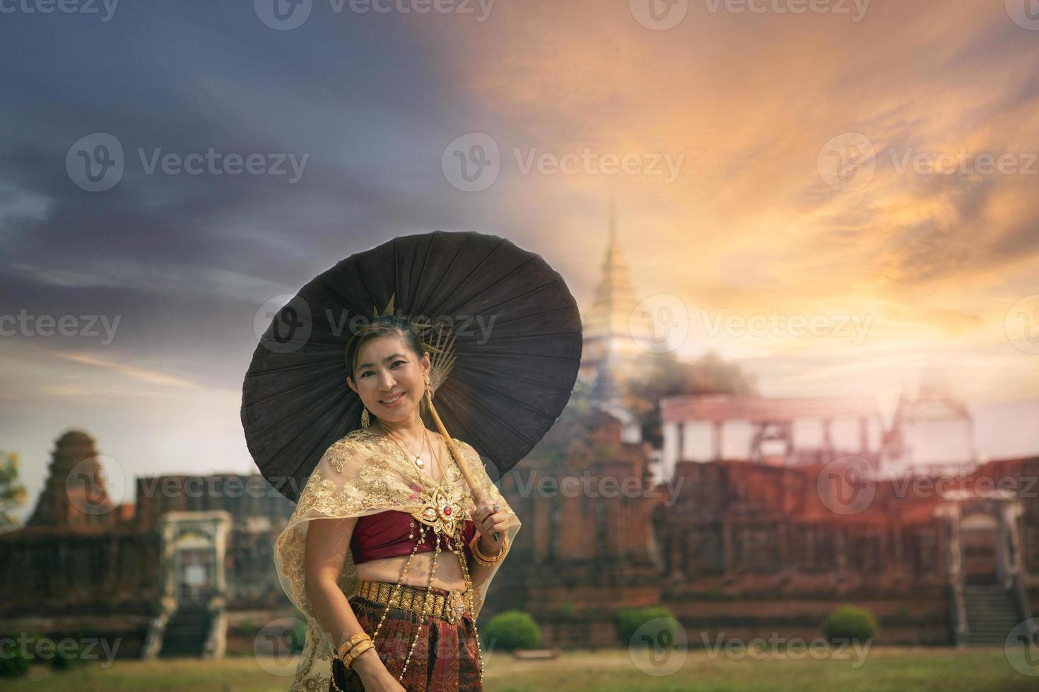 asiatisch Frau halten Bambus Regenschirm Stehen gegen alt Tempel im Ayutthaya Welt Erbe Seite? ˅ von UNESCO Thailand , Ayutthaya ist einer von die meisten Beliebt Reisen Ziel im zentral von Thailand foto