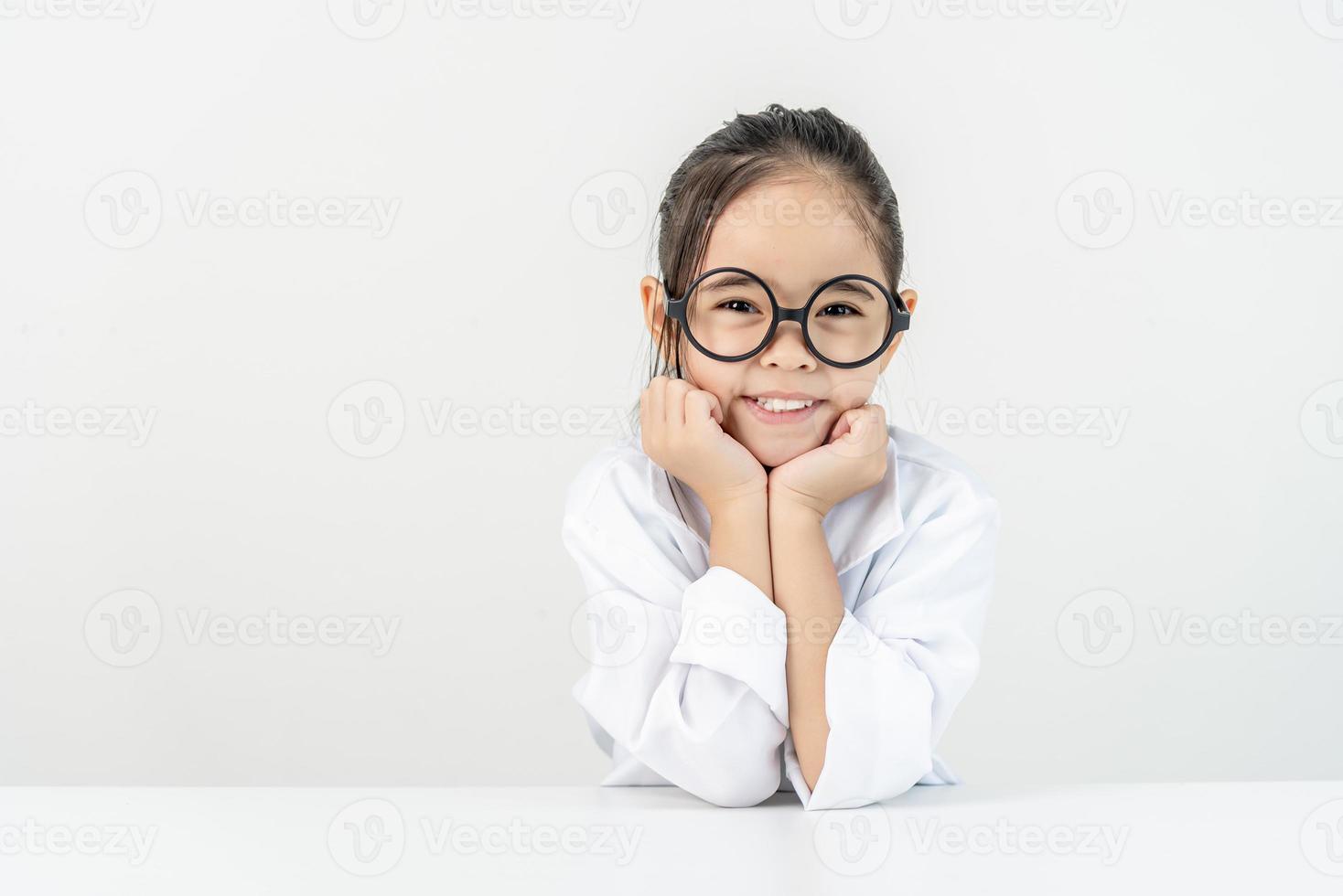 Clever Arzt wenig Mädchen mit Weiß medizinisch Mantel foto